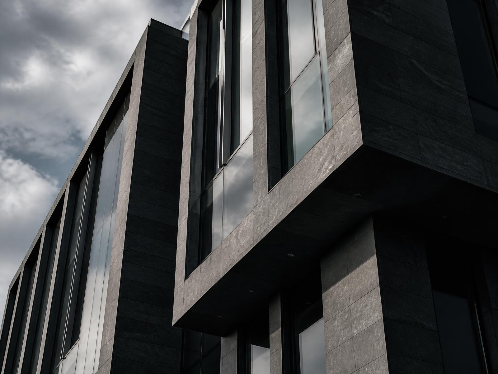 Fachada de edifício corporativo contemporâneo em pedra escura
